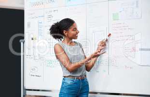 Businesswoman, coach and project manager planning a strategy and brainstorming ideas on a whiteboard during her presentation. Young entrepreneur and leader explaining plan for success during seminar