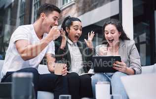Success tastes even better when youre hungry for it. a group of excited young businesspeople using a digital tablet during a meeting at a conference.