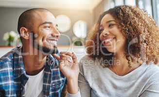Closeup of a young happy couple bonding and being affectionate while relaxing at home together. Smiling boyfriend and girlfriend hanging out and enjoying their free time on the weekend indoors