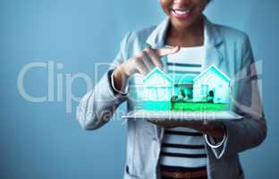 Corporate business woman holding a tablet with property cgi graphics while standing against a blue studio background alone. Happy, smiling and cheerful female designing a vr home with technology