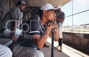 Nobody understands the game like he does. a young man watching a game of baseball from behind the fence.