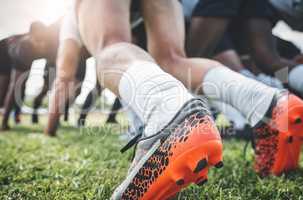 Standing firm on the ground. Low angle shot of two unrecognizable rugby teams competing in a scrum during a rugby match on a field.