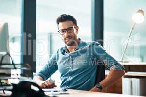 Creative entrepreneur working on computer in office after researching, browsing or searching online for startup company ideas. Portrait of confident, serious or ambitious business man sitting at desk