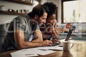 Couple with a laptop doing finance paper work, paying debt insurance loans or online ebanking together at home. Two serious people planning and looking at financial document, bills rate for mortgage