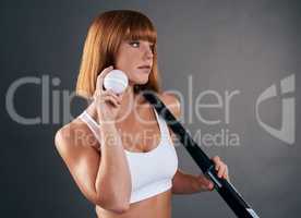 You only miss the shots you dont take. a beautiful young woman posing with hockey equipment against a grey background.
