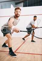 He only has eyes for the ball. two young men playing a game of squash.