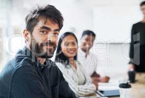 We tackle tasks as a team. Portrait of a young businessman having a meeting with colleagues in a modern office.