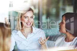 Female office worker on a break with colleagues talking and having a conversation at work. Business people spending time together inside. Smiling corporate business woman with team indoors