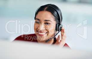 Delivering swift responses to her customers. a young businesswoman wearing a headset while working on a computer in an office.