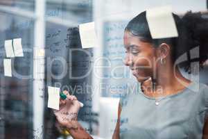 Happy, inspired and confident business woman brainstorming ideas, writing on transparent glass board with sticky notes. Powerful entrepreneur and CEO leading startup, planning company strategy.