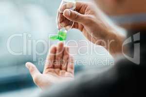 Washing your hands makes the world of difference. a businessman using hand sanitiser to disinfect his hands.