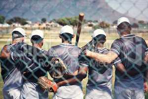 Bonded together by baseball. Rearview shot of a group of young men standing together in solidarity at a baseball game.