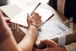 Signing to confirm proof of delivery. Closeup shot of an unrecognisable woman using a digital tablet to sign for a delivery from the courier.