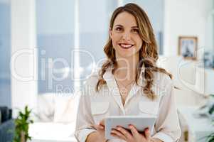 Technology is a major asset to even the smallest businesses. Portrait of an attractive young businesswoman using a digital tablet inside her office.