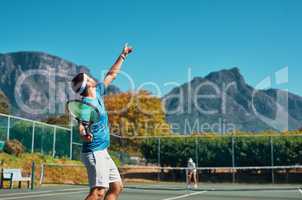 Timing is everything in this sport. a young male tennis player getting ready to serve the ball on a tennis court outdoors.