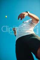 Set your goals high and dont stop till you get there. Low angle shot of a sporty young man playing tennis.