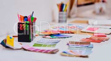 Lots of colour to spark lots of creativity. a notebook and various tools at a creative workstation.