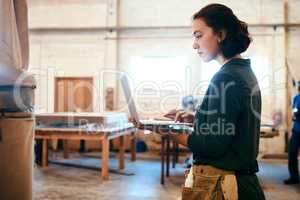 I want to try some of these designs. a female carpenter using a laptop in her workshop.