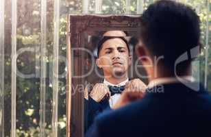 Im ready to go marry the woman of my dreams. a handsome young man getting dressed on his wedding day.