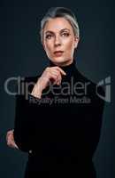 Anything black is a staple in my wardrobe. Studio portrait of a beautiful mature woman posing against a dark background.