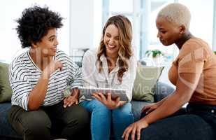 Its about staying innovative and relevant in the industry. a group of businesswomen working together on a digital tablet in an office.