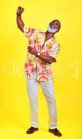 Ive still got all the moves. Full length shot of a funky and stylish senior man dancing in studio against a yellow background.