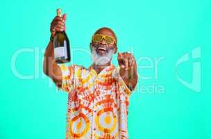 Come out and party with me. a funky and cheerful senior man celebrating and drinking champagne in studio against a turquoise background.