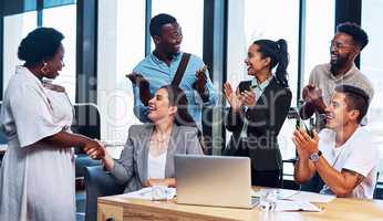 We truly feel that you deserve this promotion. a group of businesspeople applauding their colleagues in an office.