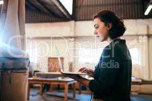 Im ready to build my clients design. a female carpenter using a laptop in her workshop.