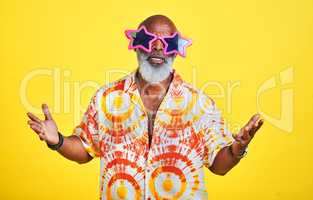 Blame it on the swag man. Portrait of a funky and stylish senior man wearing sunglasses posing in studio against a yellow background.