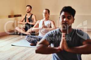 Nothing more needed. a group of young men and women meditating in a yoga class.