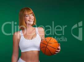 My love for basketball runs blood deep. an attractive young sportswoman standing alone and holding a basketball against a green background in the studio.