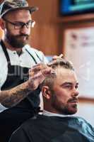 His haircuts are a definitely a cut above the rest. a handsome mature man getting a haircut at a barbershop.