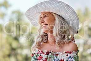 Smiles look beautiful on everyones face. an attractive senior woman smiling while sitting outdoors on a summers day.