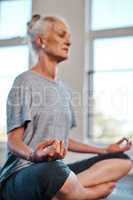 No distractions at all. a cheerful mature woman practicing yoga while meditating inside of a studio during the day.