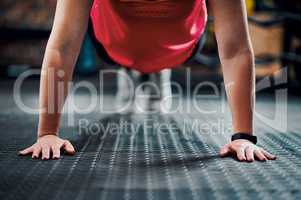 Strong is her default setting. an unrecognizable young female athlete planking in the gym.