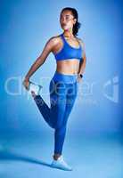 Your fitness journey starts any day you want. Full length shot of an attractive young sportswoman stretching her legs against a blue background.