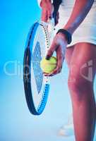 Win your service game and the results will follow. an unrecognizable young female tennis player getting ready to serve against a blue background.