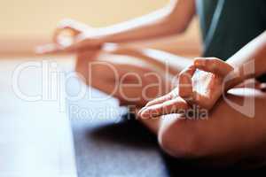 Be totally present in this moment. a woman meditating in the lotus position during a yoga session.