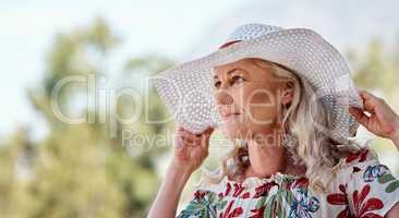 Owning her summer look. an attractive senior woman standing outdoors on a summers day.