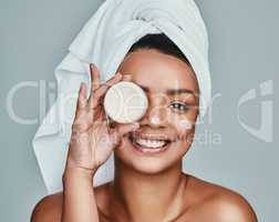 I cant go a day without moisturizing. a beautiful young woman posing with a pot of moisturizer.