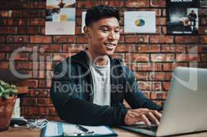 More and more people are signing up for the gym online. a handsome young male fitness instructor using a laptop while working in a gym.