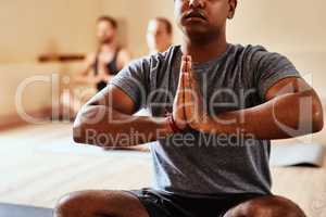 Immersed in the magic of yoga. a group of young men and women meditating in a yoga class.