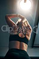 Stretch for a better workout. Rearview shot of a young woman stretching at the gym.