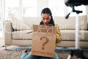 Shall we take a look inside. an attractive young businesswoman sitting in her living room and vlogging her reaction to a mystery box.