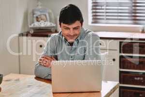 My account is set up and ready to use. a man smiling while using his laptop.