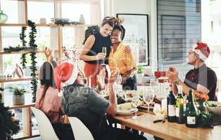 Celebrating friendship at Christmas. two affectionate young girlfriends embracing each other during Christmas lunch with their friends.