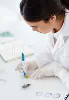 Now I will easily be able to identify my samples. a young scientist using a pen to mark a petri dish in a lab.