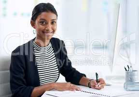 Work hard till things start working in your favor. Portrait of an attractive young businesswoman going over paperwork inside her office at work.