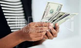 Money is the business tool that gives you choice. an unrecognizable businesswoman counting money inside her office at work.